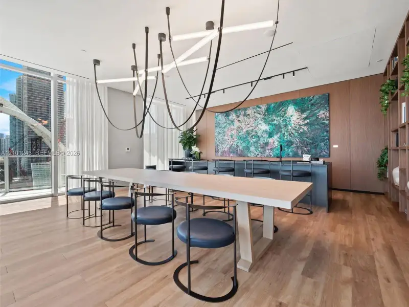 Floor-to-ceiling glass windows, wide-plank wood-finish flooring, custom wood-panel wall integration, integrated floor-to-ceiling shelving, and sculptural linear LED chandelier Floor-to-ceiling glass windows, wide-plank wood-finish flooring, custom wood-panel wall integration, integrated floor-to-ceiling shelving, and sculptural linear LED chandelier