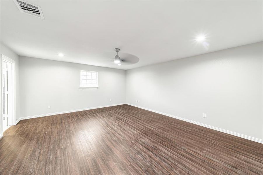 Empty room with dark wood-style flooring, ceiling fan, and recessed lighting