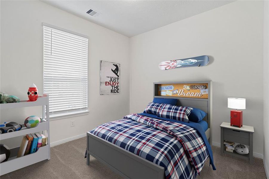 Secondary bedroom features plush carpet, neutral paint, lighting, large windows with privacy blinds and ample sized closet space.