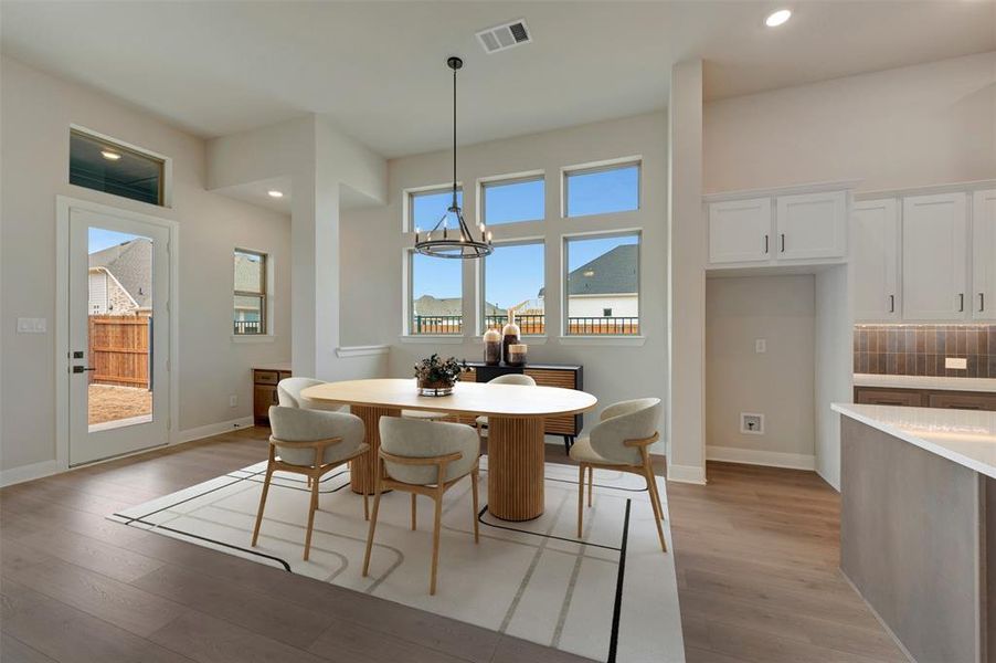 Dining area featuring light wood finished floors and a chandelier
