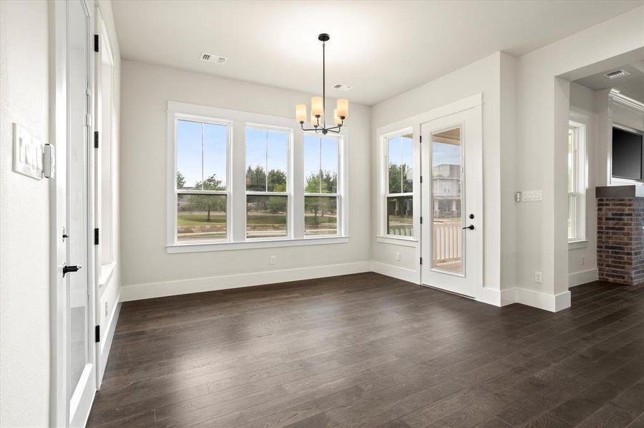 Unfurnished dining area featuring dark wood-type flooring and a chandelier