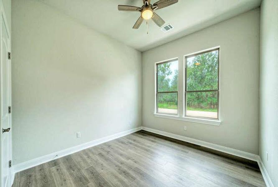 Spare room with wood finished floors and ceiling fan