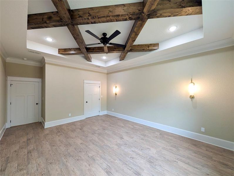 Empty room featuring coffered ceiling, light wood-style floors, beam ceiling, ceiling fan, and recessed lighting