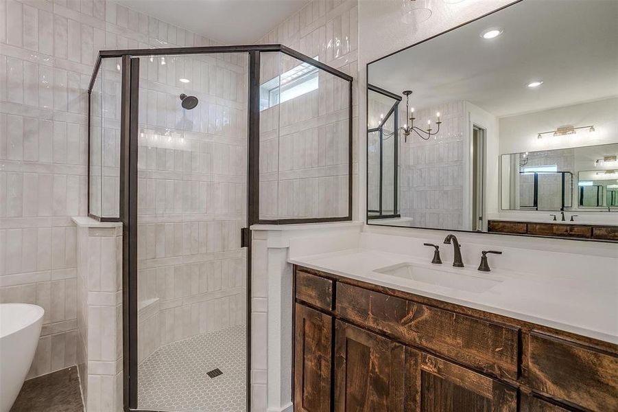 Bathroom featuring vanity, independent shower and bath, and a chandelier