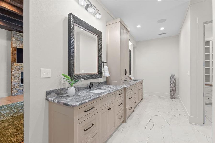 Bathroom with double vanity, a walk in closet, recessed lighting, and light marble finish flooring