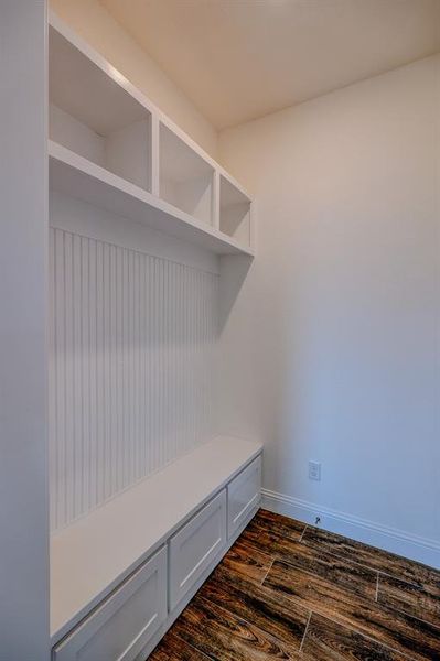 Mudroom with dark wood-style floors and baseboards