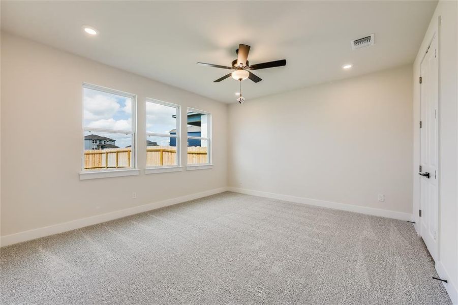 And yet another secondary bedroom showcasing the abundance of natural light with beautiful windows and a walk-in closet.