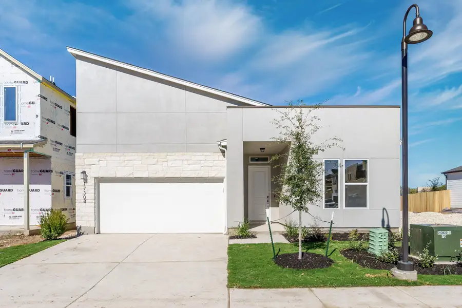 Modern facade with a sleek, low-pitched roofline and crisp landscaping. Modern facade with a sleek, low-pitched roofline and crisp landscaping.
