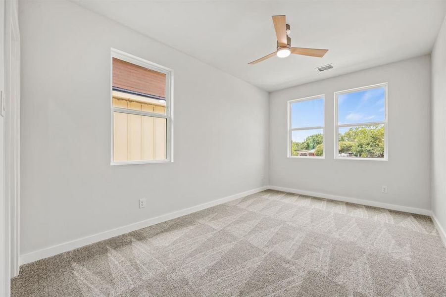 Carpeted spare room with ceiling fan