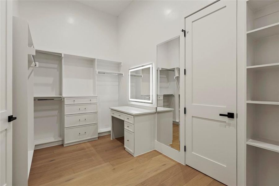 Walk in closet with light wood-style flooring
