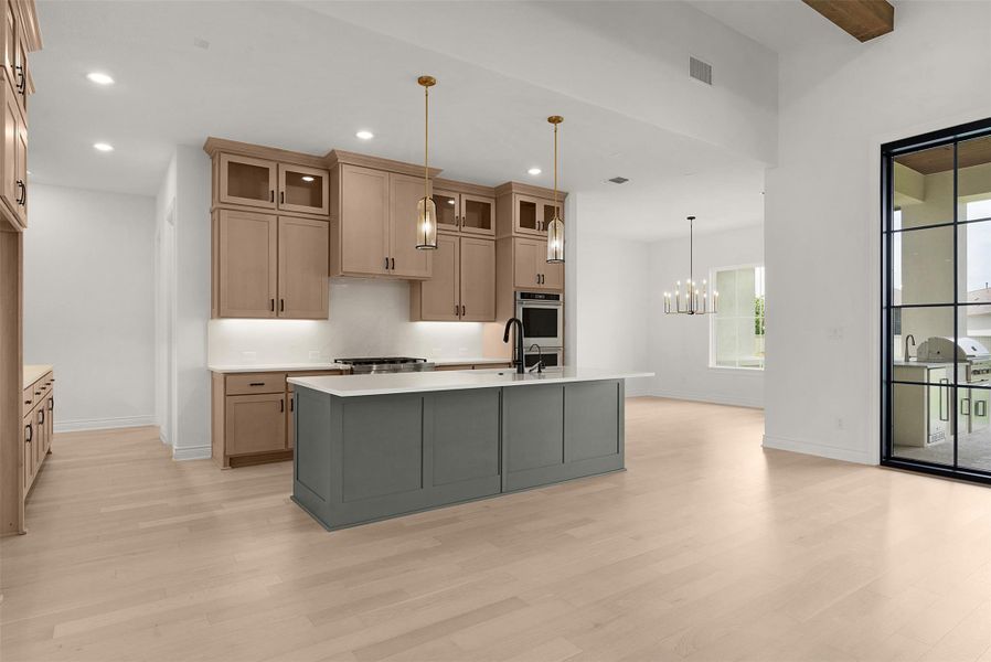 A pristine open-concept kitchen features a spacious island and gleaming hardwood floors, perfect for culinary endeavors.