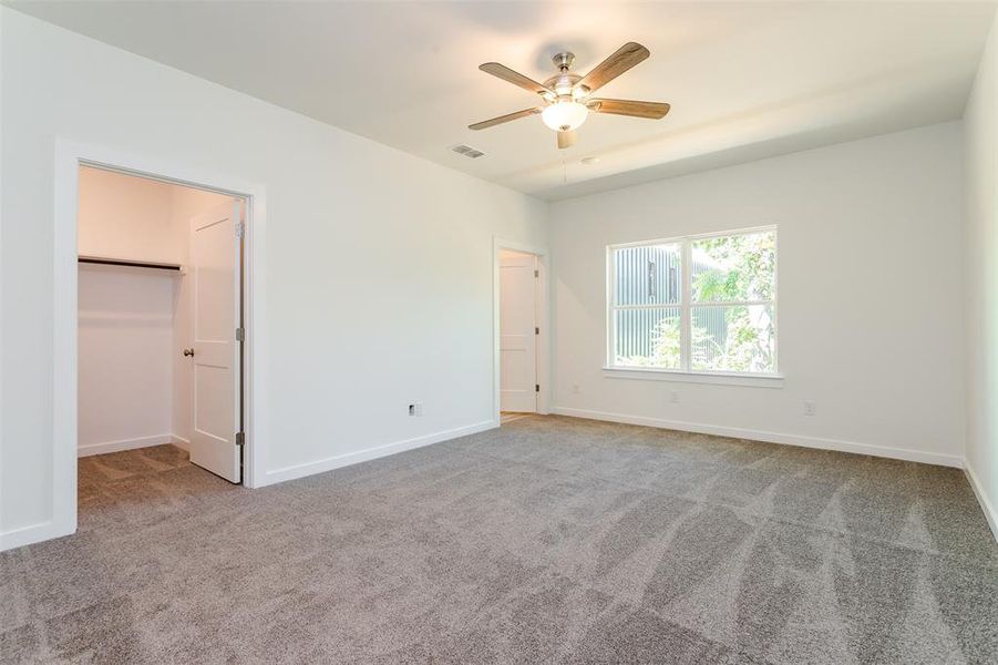 Carpeted spare room featuring ceiling fan