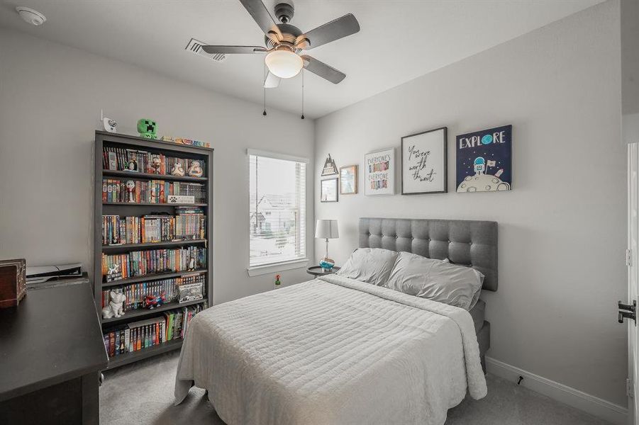 Carpeted bedroom with a ceiling fan and baseboards