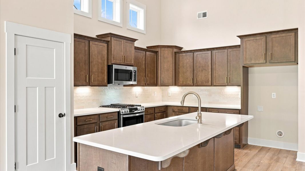 Memorable meals begin in this vibrant kitchen with quartz countertops and a thoughtfully designed island by DRB Homes