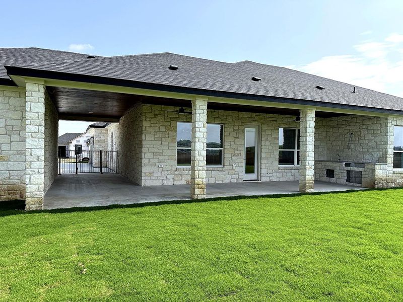 An inviting covered patio featuring an outdoor kitchen awaits al fresco gatherings. An inviting covered patio featuring an outdoor kitchen awaits al fresco gatherings.