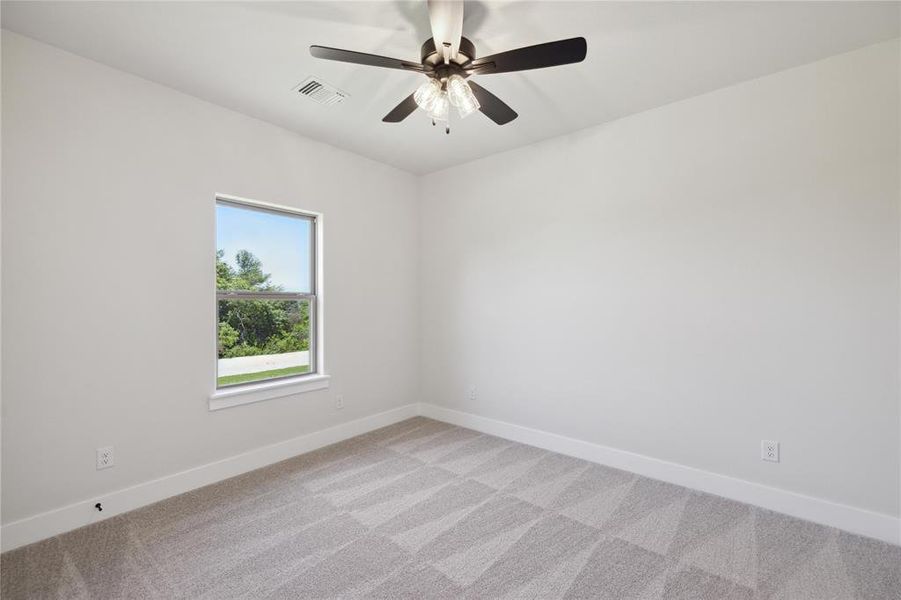 Unfurnished room featuring light carpet and ceiling fan