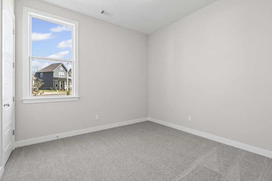 Empty room featuring light carpet and baseboards