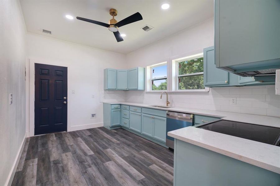 Kitchen with ceiling fan, crown molding, blue cabinets, backsplash, range, and dishwasher Kitchen with ceiling fan, crown molding, blue cabinets, backsplash, range, and dishwasher