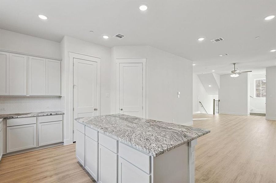 Kitchen featuring recessed lighting, visible vents, light wood-style floors, and a center island