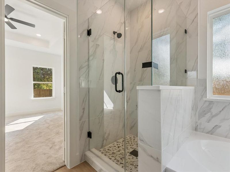 Bathroom featuring a marble finish shower, a bath, and ceiling fan
