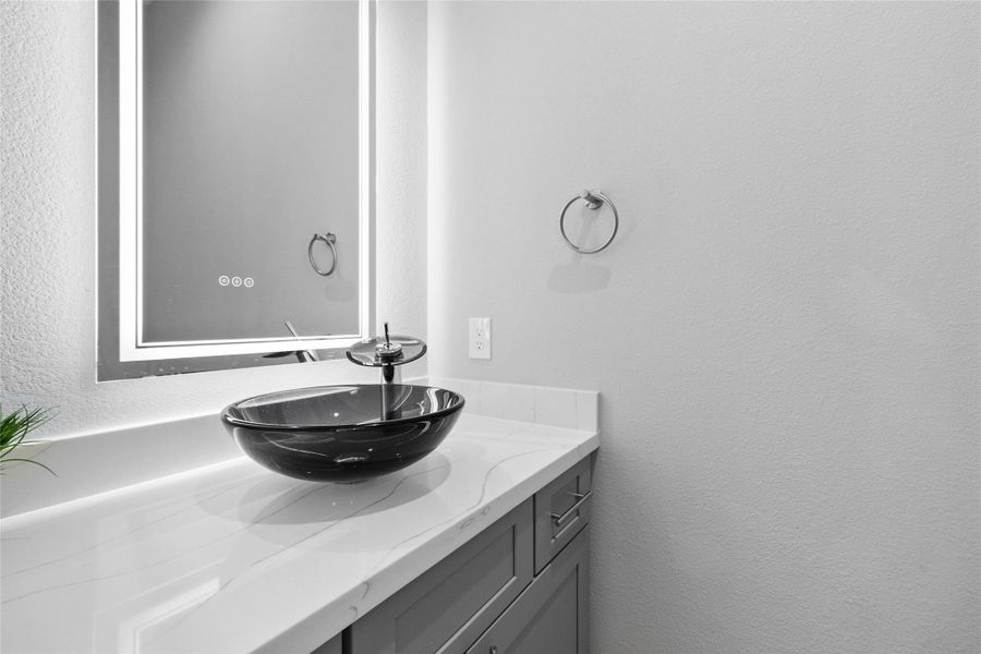 This powder bath delivers a sleek, boutique feel with a striking vessel sink, quartz countertop, and modern hardware that feels both polished and intentional. The backlit mirror adds a soft glow, making this space feel elevated while staying effortlessly functional for everyday use and guests alike. This powder bath delivers a sleek, boutique feel with a striking vessel sink, quartz countertop, and modern hardware that feels both polished and intentional. The backlit mirror adds a soft glow, making this space feel elevated while staying effortlessly functional for everyday use and guests alike.
