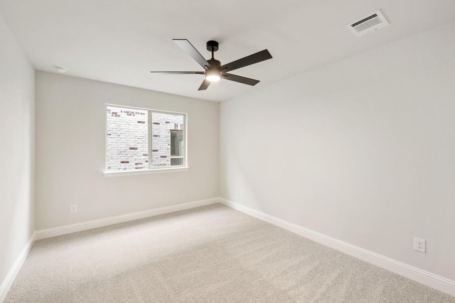 Empty bedroom with light carpet, white walls, ceiling fan, and single window