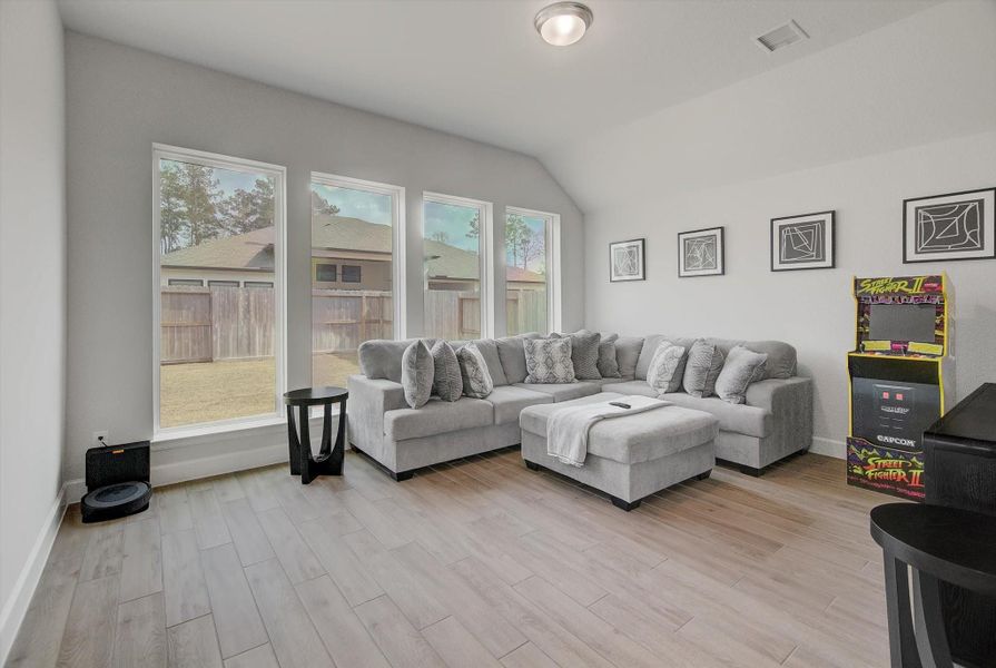 The game room also features a wall of windows, filling the space with natural light and creating an open, inviting atmosphere that enhances its role as an entertainment hub.