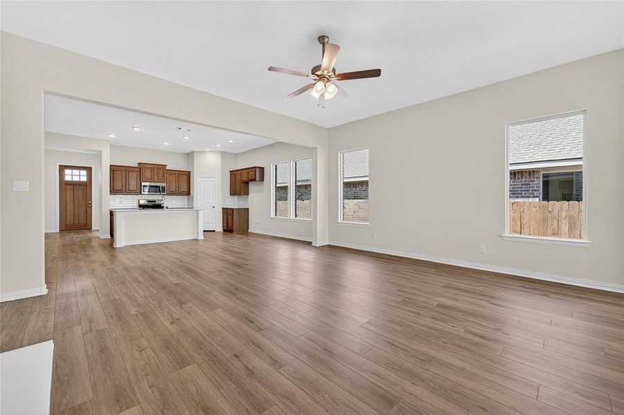 Unfurnished living room featuring light wood-style flooring, ceiling fan, and recessed lighting