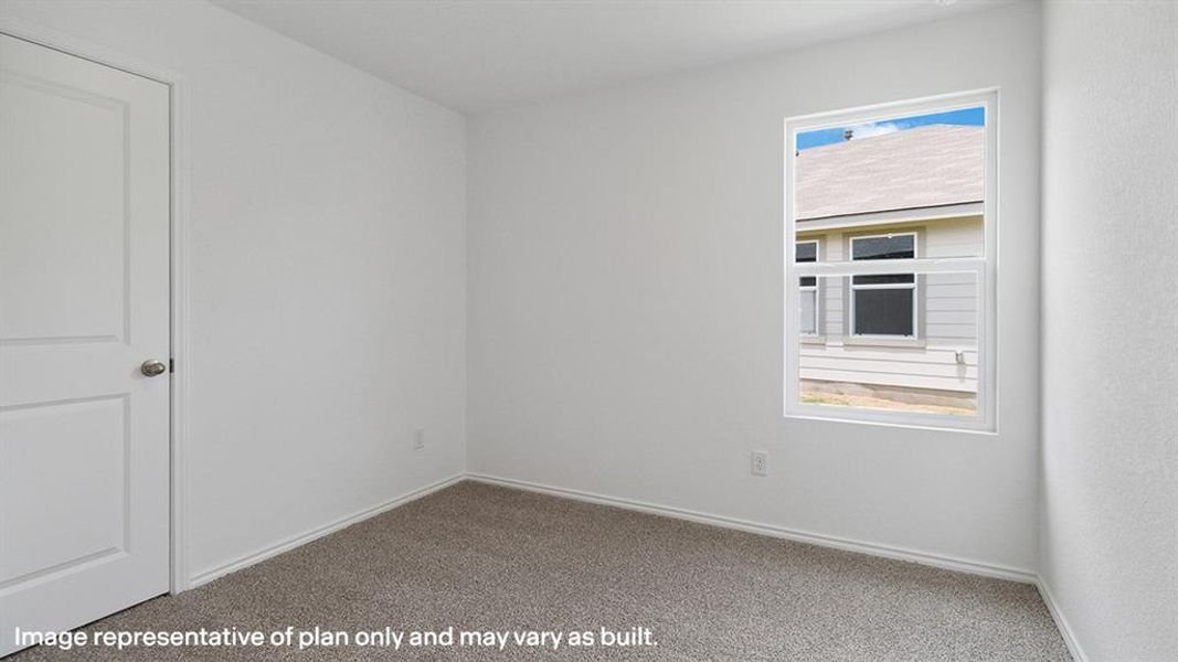 Carpeted spare room featuring baseboards