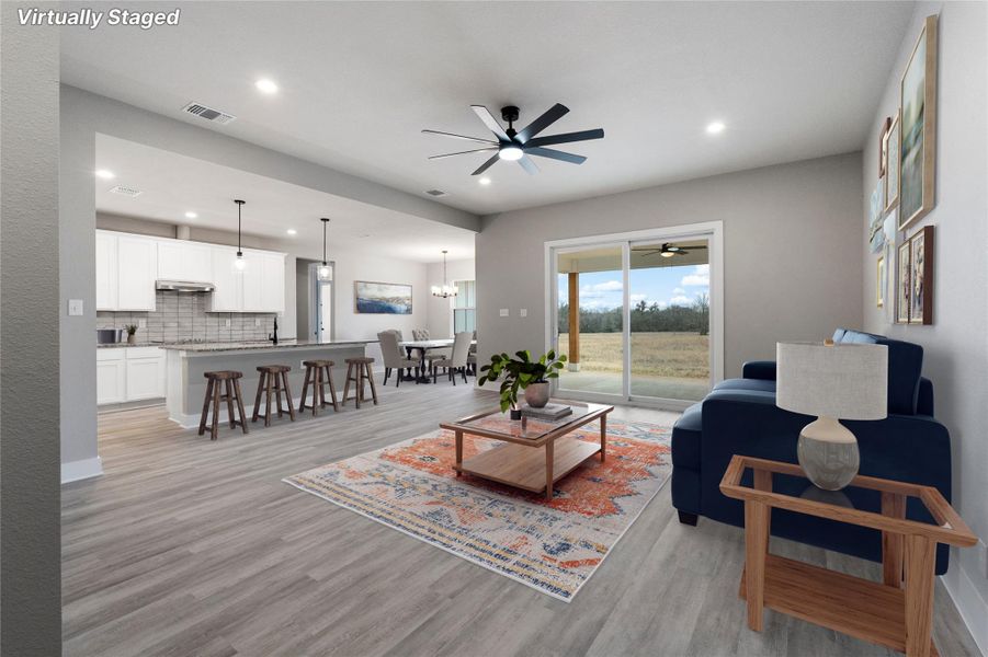 Living room with a ceiling fan, light wood finished floors, recessed lighting, and a chandelier