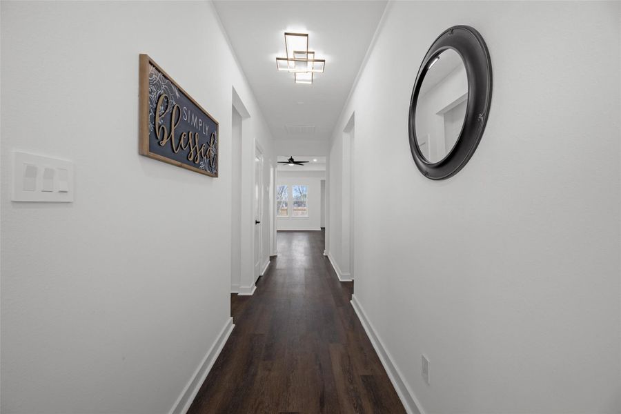 Hallway features dark wood flooring, white walls, and modern lighting. Hallway features dark wood flooring, white walls, and modern lighting.