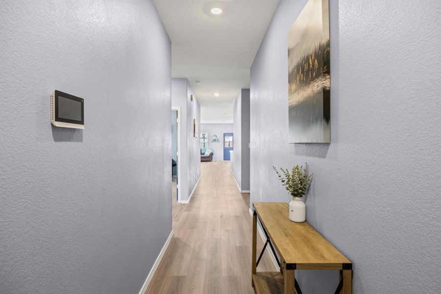 The foyer features a hallway that leads into the home with LVP floors, your home's security system, and recessed lighting The foyer features a hallway that leads into the home with LVP floors, your home's security system, and recessed lighting
