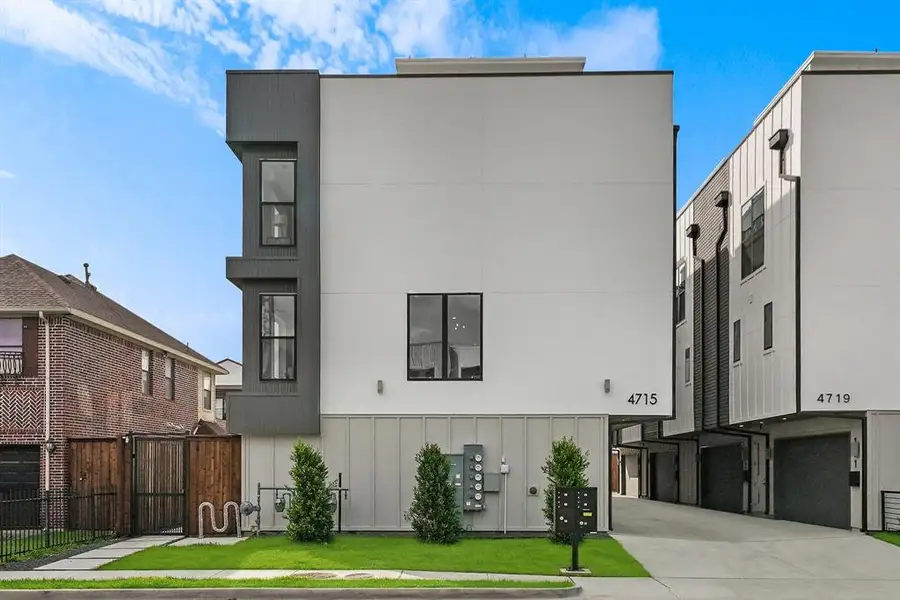 Modern multi-story facade featuring a white stucco finish with dark panel accents Modern multi-story facade featuring a white stucco finish with dark panel accents
