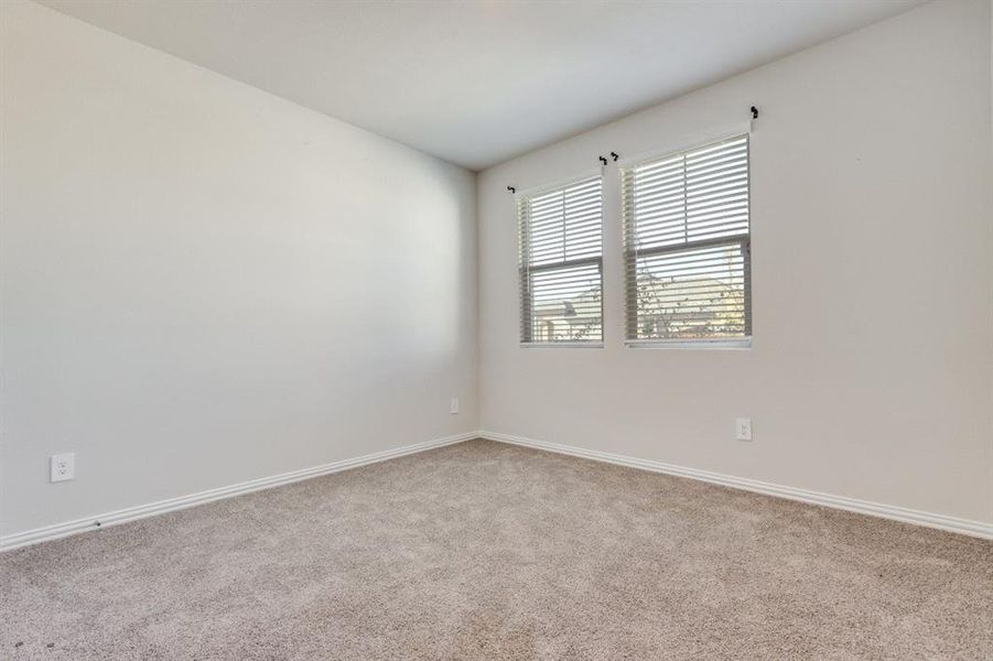 Spare room featuring light carpet and baseboards