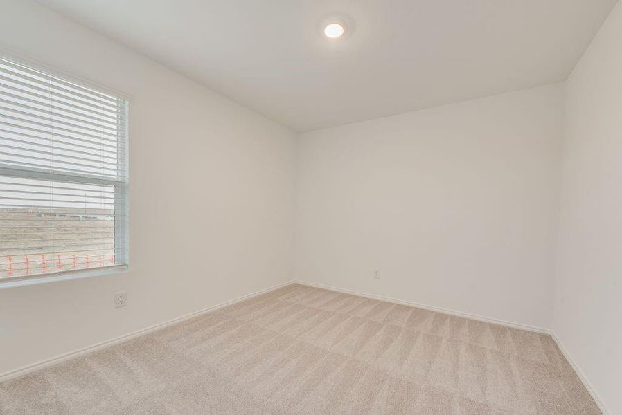 Empty room featuring light carpet and baseboards