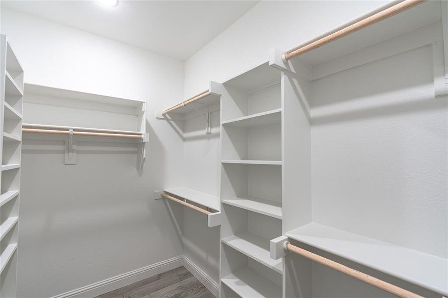 Spacious closet with dark hardwood / wood-style flooring