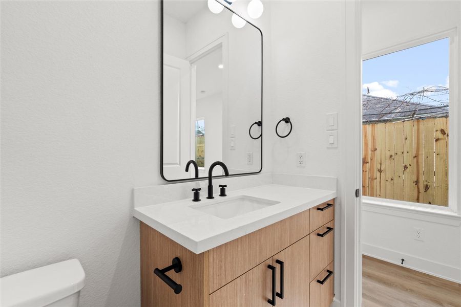 Stylish entry with modern door, staircase, and a convenient half bath nearby.