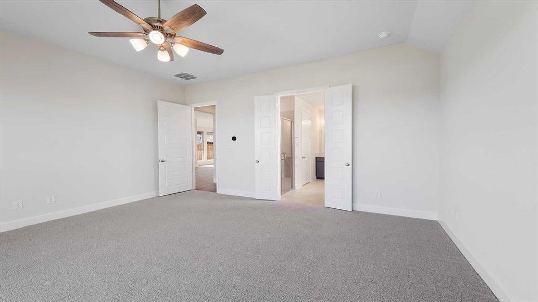 Unfurnished bedroom featuring ceiling fan, light carpet, and vaulted ceiling