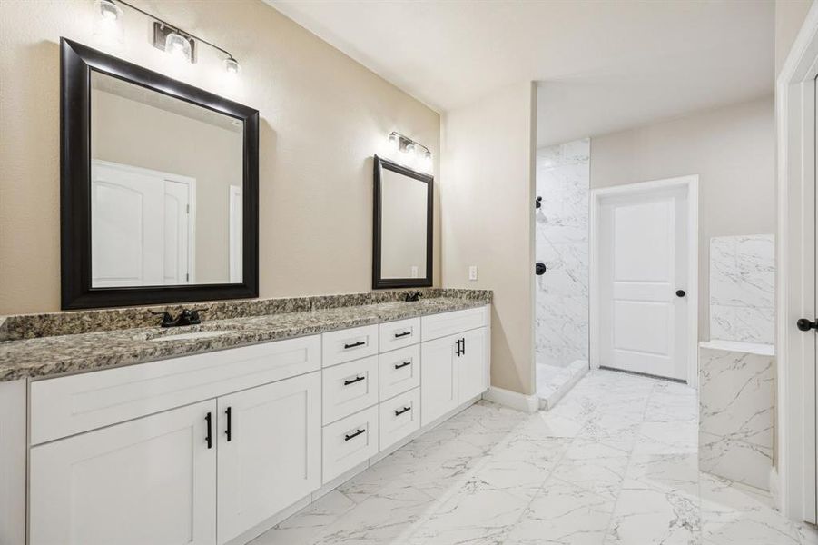 Bathroom with light marble finish floors, double vanity, and a marble finish shower Bathroom with light marble finish floors, double vanity, and a marble finish shower