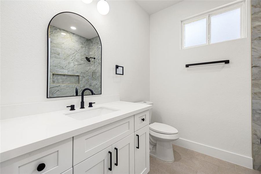 Bathroom #2-This photo showcases a bright, carpeted room with neutral walls, a ceiling fan, and double doors leading to a closet. A large window in the adjacent room provides natural light, creating a welcoming atmosphere.