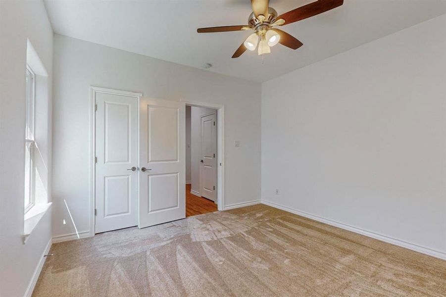 Unfurnished bedroom #4 with ceiling fan, a closet, and light colored carpet