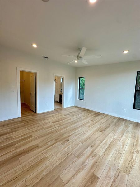Unfurnished bedroom featuring recessed lighting, light wood-style flooring, a ceiling fan, and connected bathroom Unfurnished bedroom featuring recessed lighting, light wood-style flooring, a ceiling fan, and connected bathroom