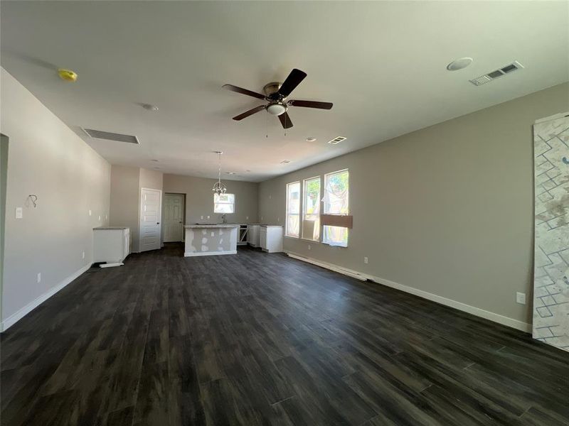 Unfurnished living room with dark hardwood / wood-style flooring and ceiling fan