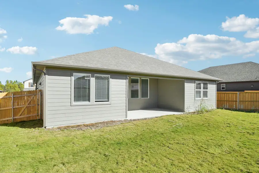 Back of house with a patio, a fenced backyard, and a shingled roof Back of house with a patio, a fenced backyard, and a shingled roof