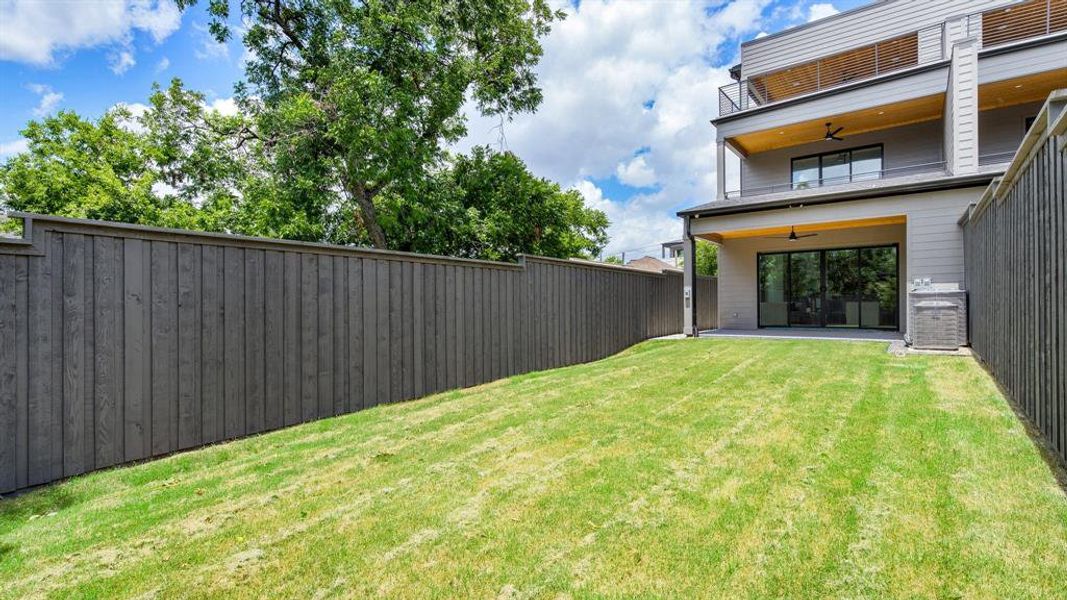 View of yard with a balcony, central AC, and ceiling fan