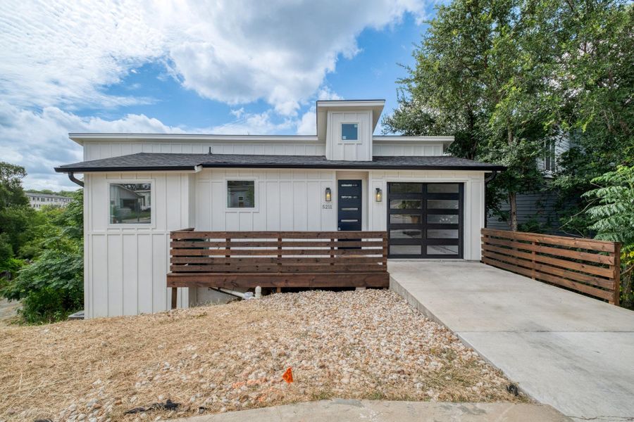 Modern architecture defines this dwelling, boasting a sleek garage door and inviting front entry. Modern architecture defines this dwelling, boasting a sleek garage door and inviting front entry.