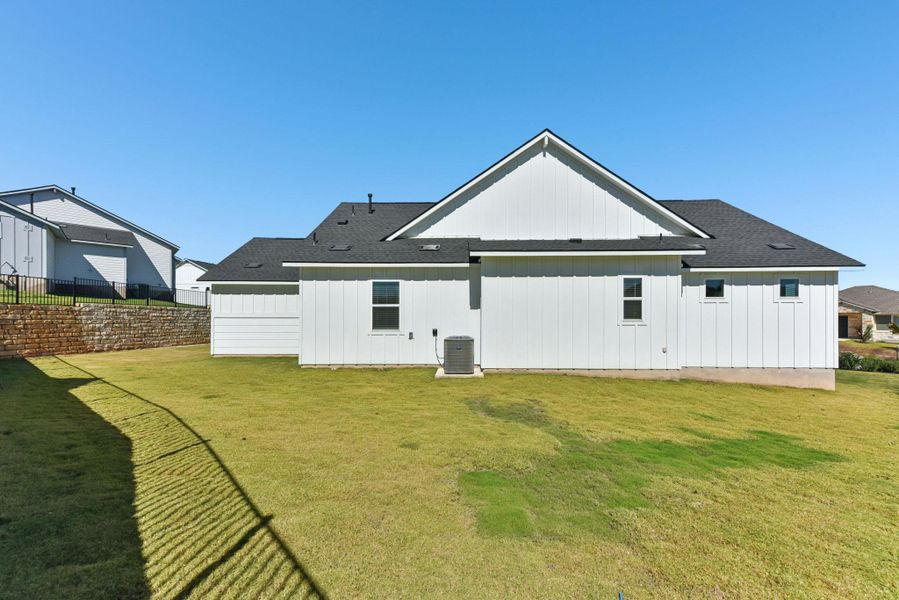 Rear view of house with a shingled roof and board and batten siding