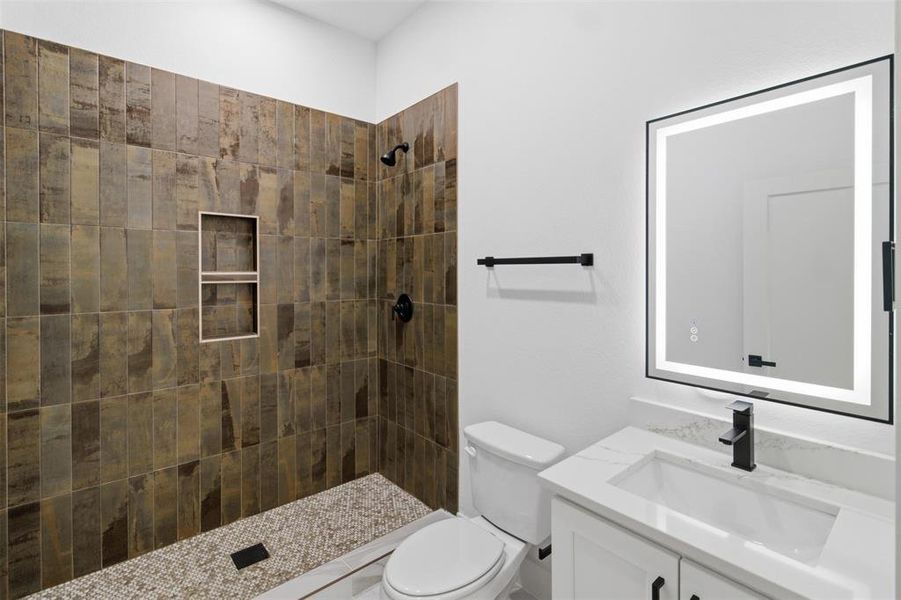 Full bath featuring vanity and tiled shower