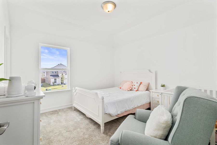 Bedroom with light colored carpet and baseboards