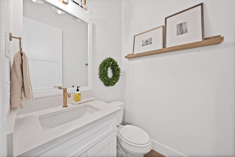 White vanity with integrated rectangular sink and brass-finish faucet White vanity with integrated rectangular sink and brass-finish faucet